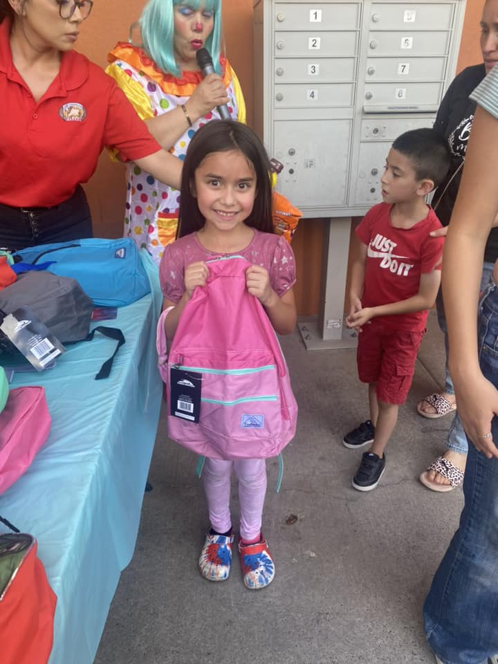 little girl smiling holding new backpack